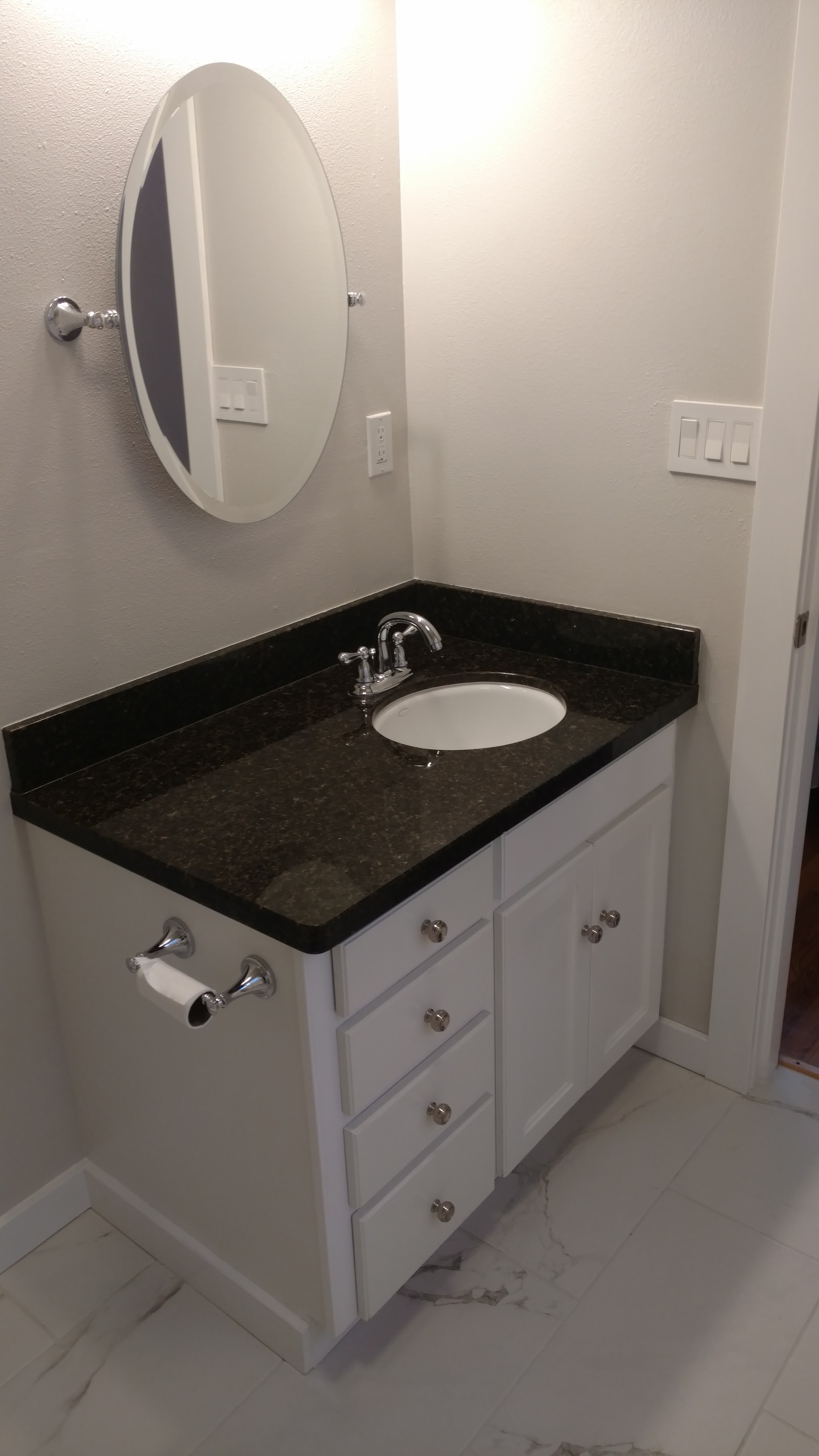 Finished bathroom vanity with dark granite countertop